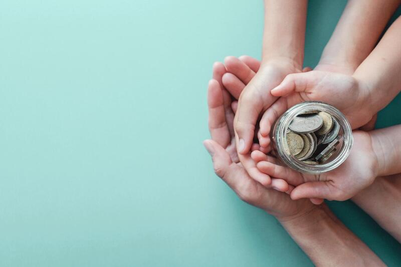 child-adult-holding-money-jar-donation-saving-concept.jpg